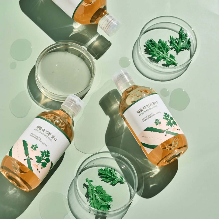 Round Lab Mugwort Calming Toner 300 ml beroligende toner i klare flasker ved siden av friske grønne burotblader.